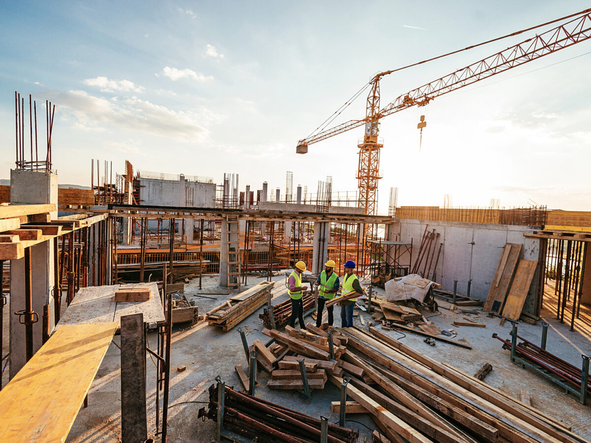 3 Male Construction workers at an open, active construction site